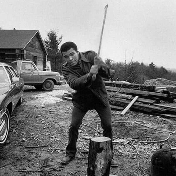 Muhammad Ali chopping wood at Deer Lake training camp Pennsylvania 1973 black and white photograph